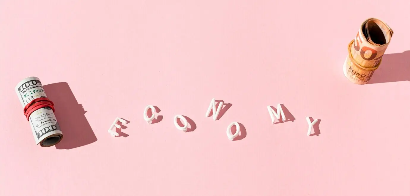 Draufsicht auf Banknotenrollen und das Wort „Economy“.